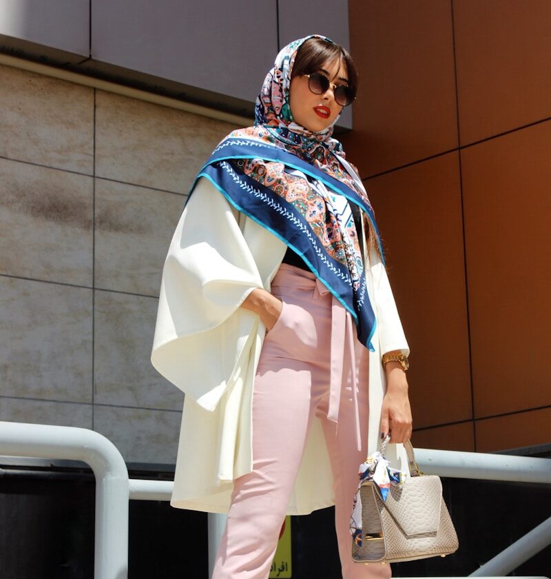 woman wearing pink pants holding grey leather handbag